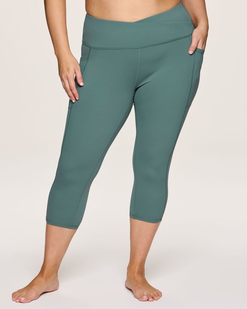 Front of a model wearing a size 1X Plus Crossover Ultra Hold Capri in Sea Green by RBX Active. | dia_product_style_image_id:348468